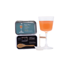 Alcohol kit with a glass, straws, and a wooden spoon next to a cocktail.