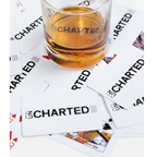 Glass of whiskey labeled 'Uncharted' on playing cards with 'Uncharted' branding.